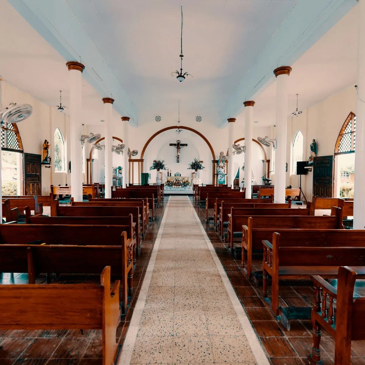 The quiet interior of a church with empty pews facing the altar