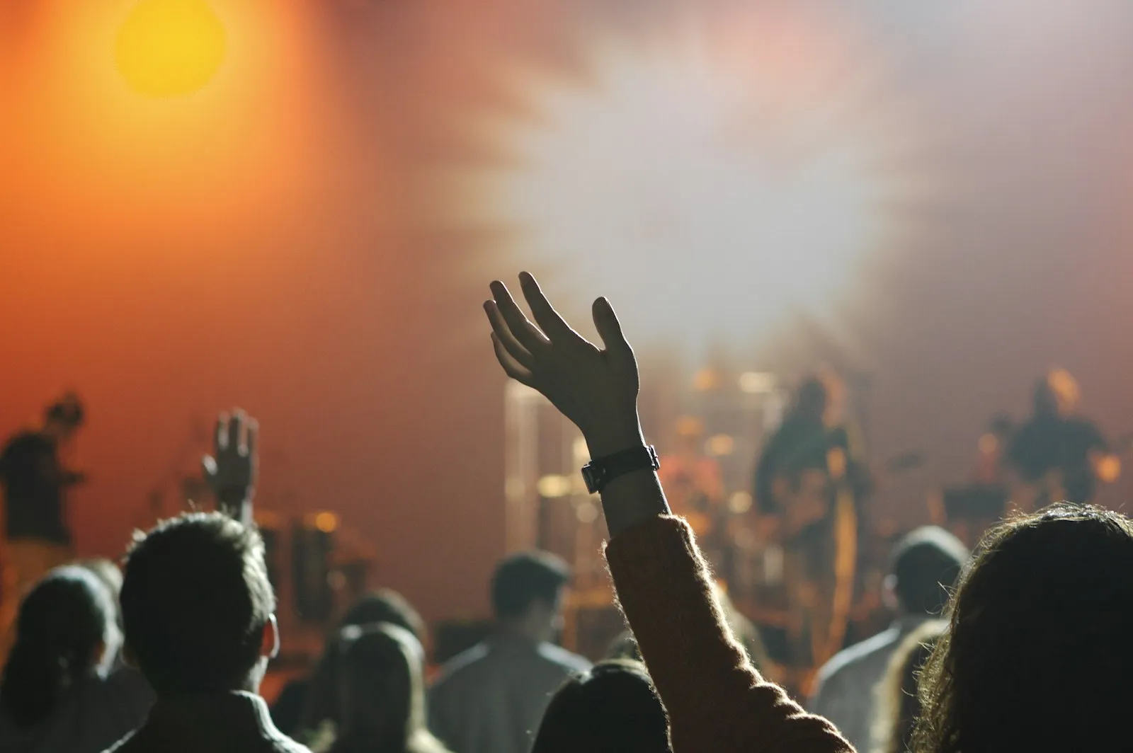 A worshipper lifting their hand in praise during a service